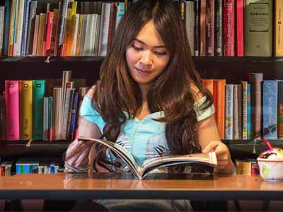 girl reading book in library 